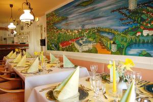 a row of tables in a restaurant with a painting at Hotel Hohenzollern in Schleswig
