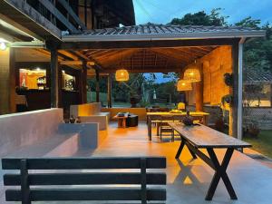 an outdoor patio with tables and a bench and a table at Jardim da Amazônia Lodge in Sao Jose do Rio Claro