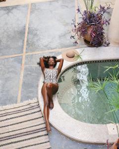 - une femme en tenue de ponte à côté d'une piscine dans l'établissement Riad Dar Ten, à Marrakech