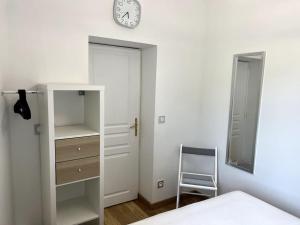 a bedroom with a bed and a clock on the wall at Deauville: superbe appartement in Deauville