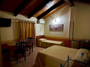 a hotel room with two beds and a table and a tableablish at Cilento Antico in Stella Cilento