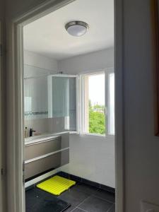 ein weißes Badezimmer mit gelber Matte auf dem Boden in der Unterkunft maison neuve au porte de paris in Bagneux