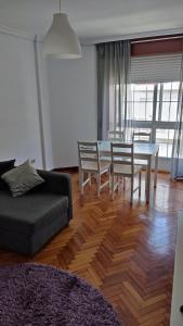 ein Wohnzimmer mit einem Sofa, einem Tisch und Stühlen in der Unterkunft Apartamento Julia in Vilagarcia de Arousa