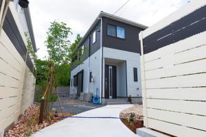 uma casa a preto e branco com uma entrada em 新規オープン新築つくばガーデンハウス一棟貸切チャオ No361 em Tsukuba