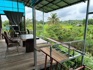 une terrasse en bois avec une table et des chaises. dans l'établissement ผาน้ำย้อยอะไหล่เบนซ์ Homestay, à Ban Kut Khae Don