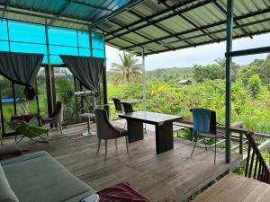 une terrasse en bois avec une table et des chaises. dans l'établissement ผาน้ำย้อยอะไหล่เบนซ์ Homestay, à Ban Kut Khae Don