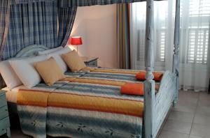 een slaapkamer met een bed met een oranje en blauwe deken bij Beach Shack in Klorakas +14 foto's