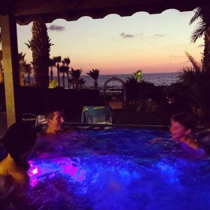 a group of people in a pool with blue lights at Beach Shack in Khlorakas