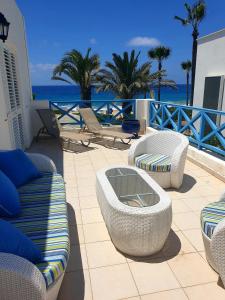 een patio met banken en stoelen en de oceaan bij Beach Shack in Klorakas