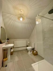 a bathroom with a toilet and a sink and a shower at The Coach House Harthill in Harthill