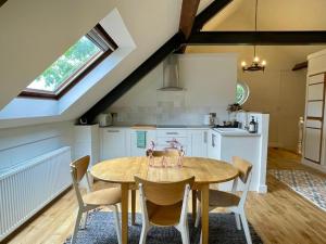 a kitchen with a wooden table and chairs in a room at The Coach House Harthill in Harthill