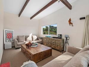 a living room with a couch and a coffee table at Pukawa Country Lodge - Pukawa Bay Holiday Home in Tokaanu