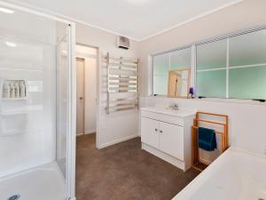 a white bathroom with a sink and a shower at Pukawa Country Lodge - Pukawa Bay Holiday Home in Tokaanu +26 photos