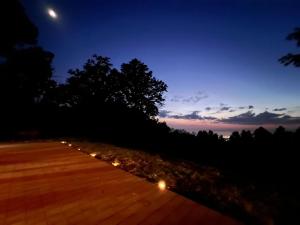 - une vue nocturne sur un chemin en bois éclairé dans l'établissement Agriturismo Difesa del Monte, à Grisolia