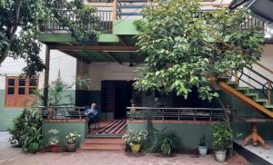 a person sitting on a bench in front of a building at Southcanal Holidays in Alleppey