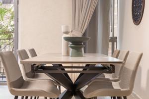- une table à manger avec des chaises et un vase dans l'établissement The Charming apartment Mamila, à Jérusalem
