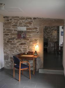 une table et une chaise dans une chambre avec un mur en pierre dans l'établissement Le Clos Crista Galli, à Saint-Junien