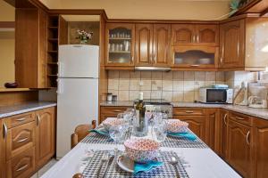 a kitchen with a table with wine glasses on it at Villa Roxa Montuoso in Agios Leon