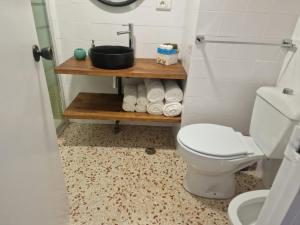 a bathroom with a toilet and a sink and towels at Apartamento Mar y Arena in Cullera