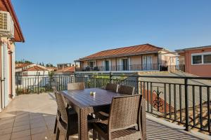 a patio with a table and chairs on a balcony at Villa Roxa Montuoso in Agios Leon
