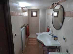 bagno con 2 servizi igienici, lavandino e specchio di Sofia a Castro di Lecce