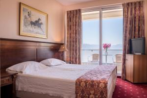 una camera d'albergo con letto e TV di Dolphin Resort & Conference a Kalamos