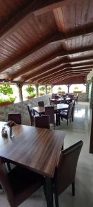 comedor con mesas y sillas de madera en Pensiune Restaurant Alex, en Copalnic