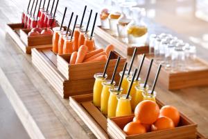 a buffet with carrots oranges and juice in wooden containers at Riyadh Diplomatic Quarter - Marriott Executive Apartments in Riyadh