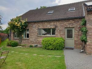 a brick house with a door and a yard at Logeren in Aldeneik in Maaseik
