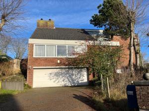 a red brick house with a white garage at Zuidwest Zeven free parking! in Zandvoort