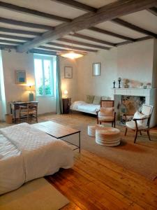 een slaapkamer met een bed en een woonkamer bij Les Grands Vents in Chervettes