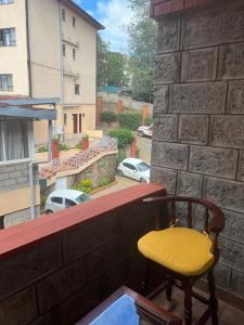 a yellow chair sitting on the ledge of a balcony at Lux Suites Lantana Road Apartments westlands in Nairobi