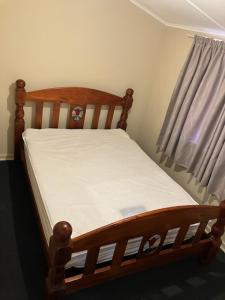 - un lit bébé en bois dans une chambre avec fenêtre dans l'établissement Brockman Cottage Denham, à Denham