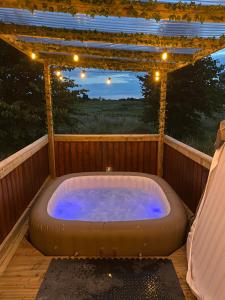 a hot tub on a deck with a pergola at Horse Truck Tiny Home in Swords