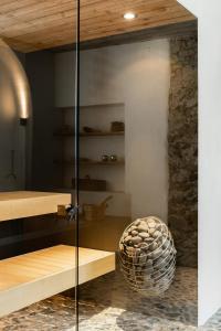 una puerta de cristal en una habitación con una pared de piedra en Ein Kraftort und architektonisches Juwel, en Ardez