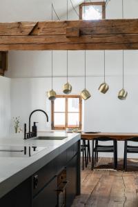 cocina con mesa de comedor y luces colgantes en Ein Kraftort und architektonisches Juwel, en Ardez