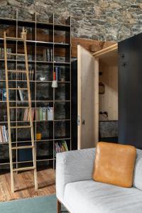 a living room with a couch and a book shelf at Ein Kraftort und architektonisches Juwel in Ardez