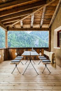 Habitación con mesa, sillas y suelo de madera. en Ein Kraftort und architektonisches Juwel, en Ardez