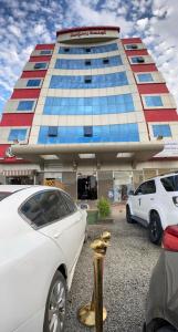biały samochód zaparkowany przed budynkiem w obiekcie رسلين للشقق المخدومة w mieście Ha'il