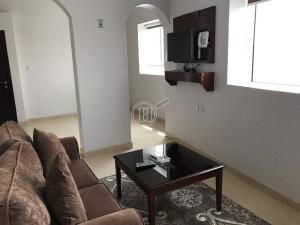 a living room with a couch and a coffee table at رسلين للشقق المخدومة in Hail