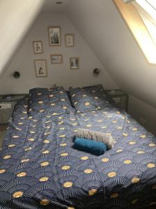a bed with a blue comforter in a room at La « cabaneste » dans Arreau in Arreau