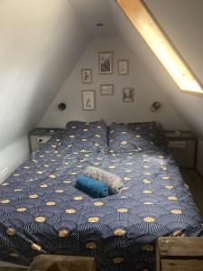 a bed with a blue and yellow comforter in a attic at La « cabaneste » dans Arreau in Arreau
