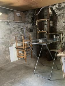 a room with a table and chairs and a stone wall at La « cabaneste » dans Arreau in Arreau