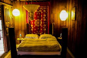 1 dormitorio con 1 cama con 2 lámparas en Shanta Ghar A Rustic Guesthouse en Chitwan