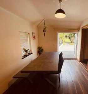 uma sala de jantar com uma mesa de madeira e uma janela em River Cottage em Mullingar