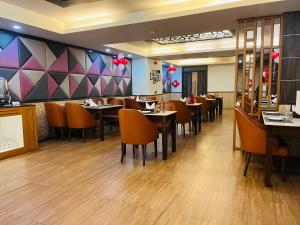 uma sala de jantar com mesas e cadeiras num restaurante em Hotel Myriad em Lucknow