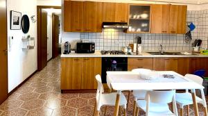uma cozinha com uma mesa branca e cadeiras brancas em Al B6 CLOSE TO VENICE em Mogliano Veneto