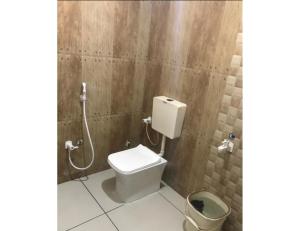 a bathroom with a toilet and a shower at Hotel Sukhnath, Somnath in Somnath