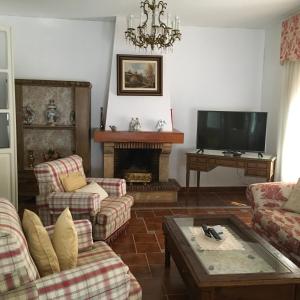 sala de estar con chimenea y TV en Casa Maria, en Camuñas