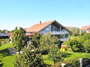 a house with a red roof on a green yard at Rooms Mirabella in Rakovica